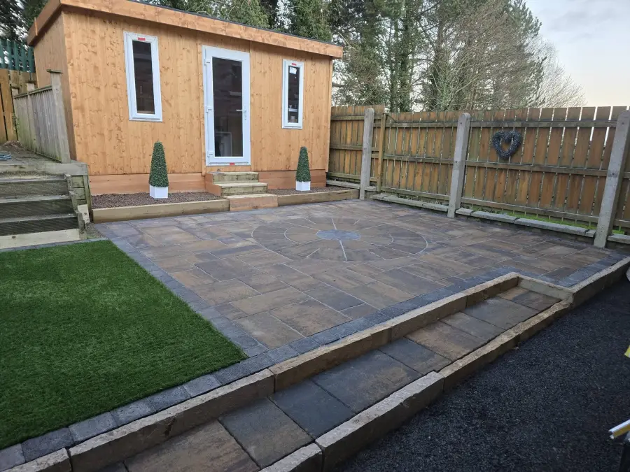 Full garden transformation with circle patio feature, artificial grass and stone walling by Perfect Paving Belfast